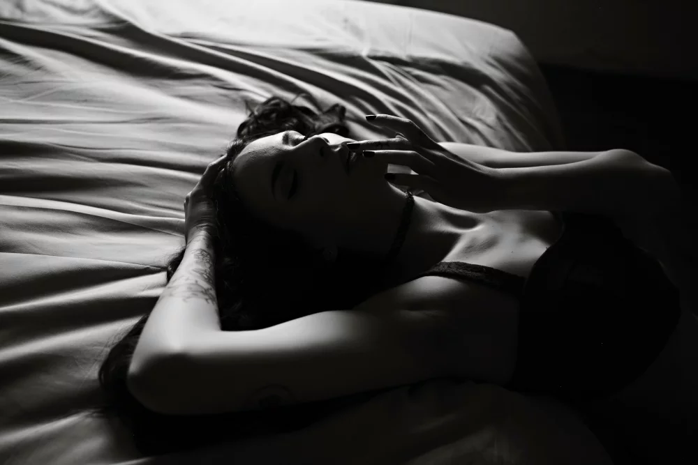 Image of image of a woman hanging off the bed wearing lingerie